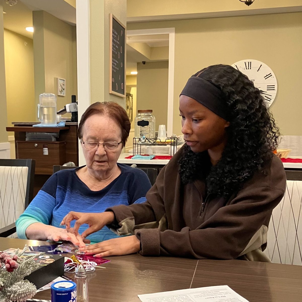 A team member helping a resident with a craft activity